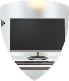 Ein Schreibtisch auf dem eine Computerbildschirm, Tastatur und eine Maus stehen.