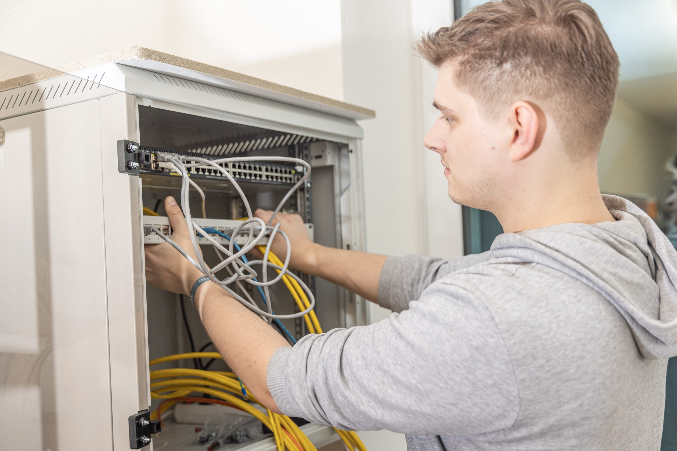 IT-Guard-Mitarbeiter arbeitet an der Verkabelung eines Netzwerkschranks